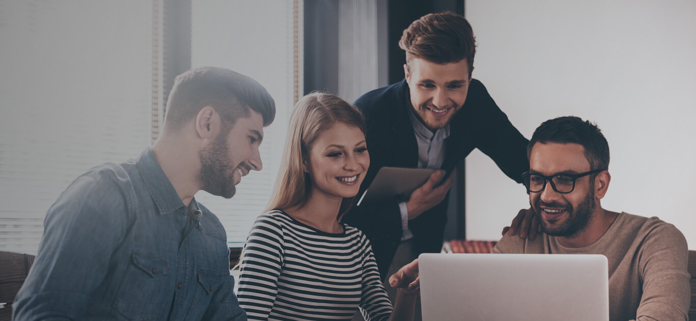 Grupo de personas reunidas mirando un computador